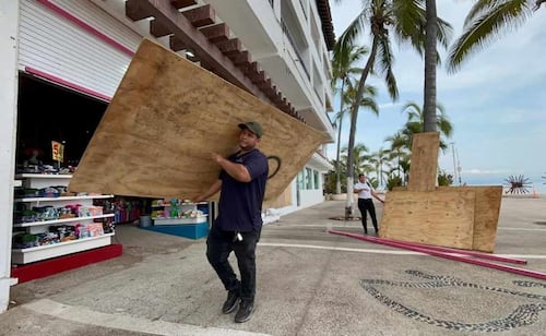 Comerciantes blindan malecón de Puerto Vallarta ante amenaza de "Simón"; usan tablones y costales para proteger sus negocios